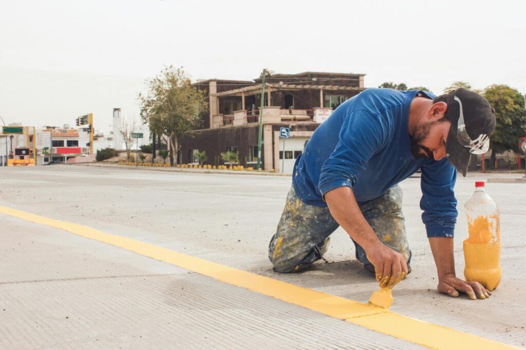man painting markings on the road